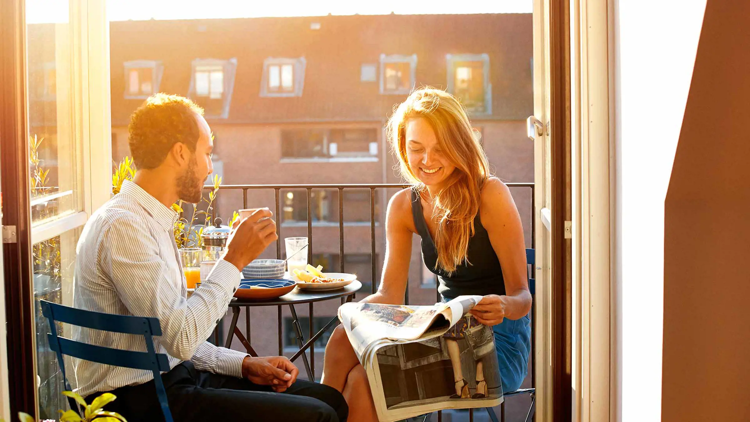 pareja joven leyendo noticias mientras desayunan