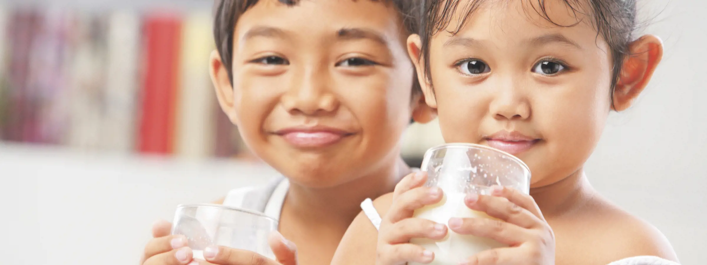 niños pequeños bebiendo alimento lácteo